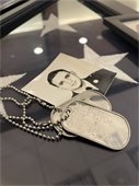 Dog Tags of James Henry Taylor rest beside a photograph. 