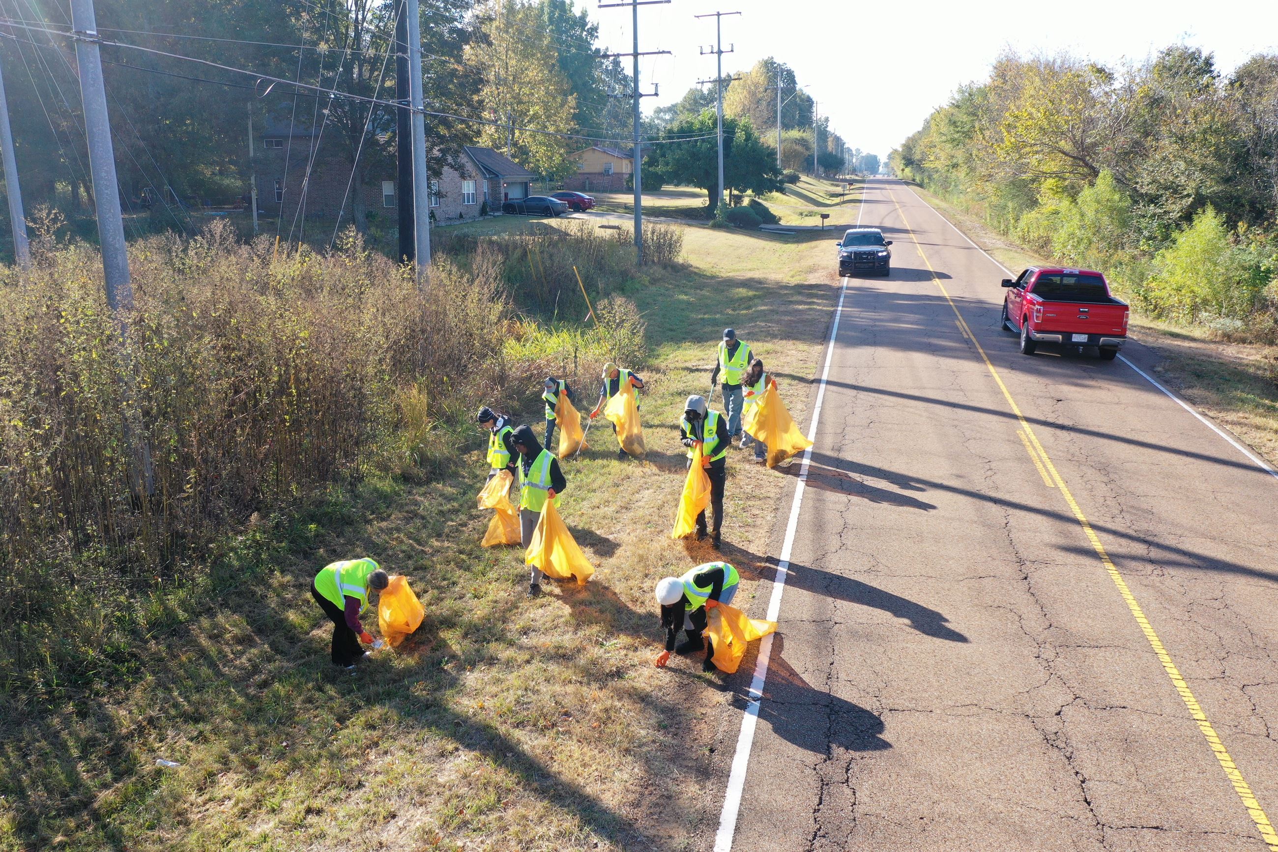 residents work on icking up trash during community clean up day