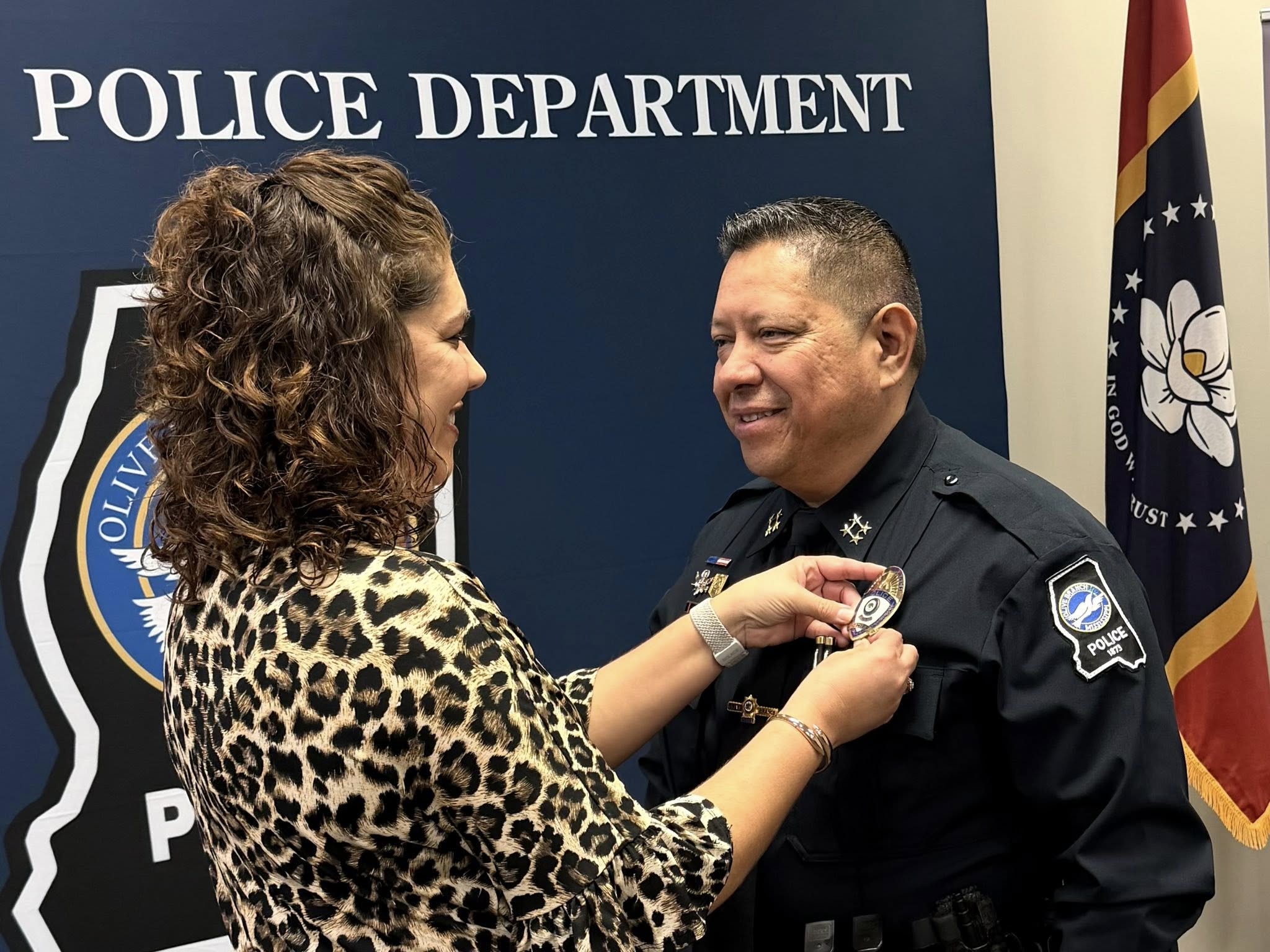 New Chief of Police Carlos Garcia has his new badge pinned by wife Glenda Garcia